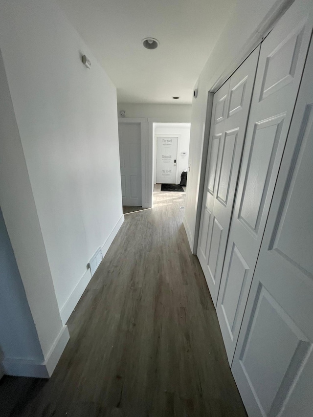 hallway with dark hardwood / wood-style flooring