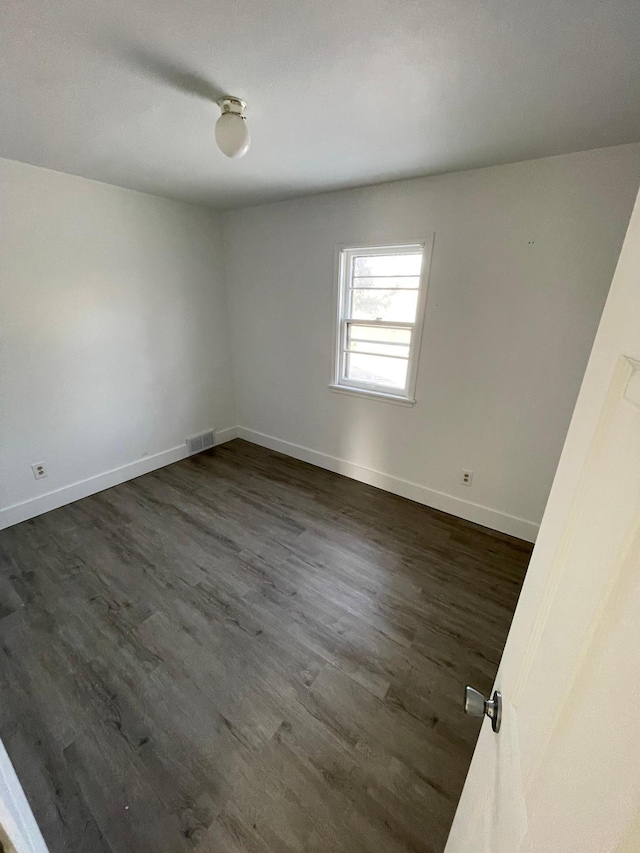 unfurnished room with dark wood-type flooring