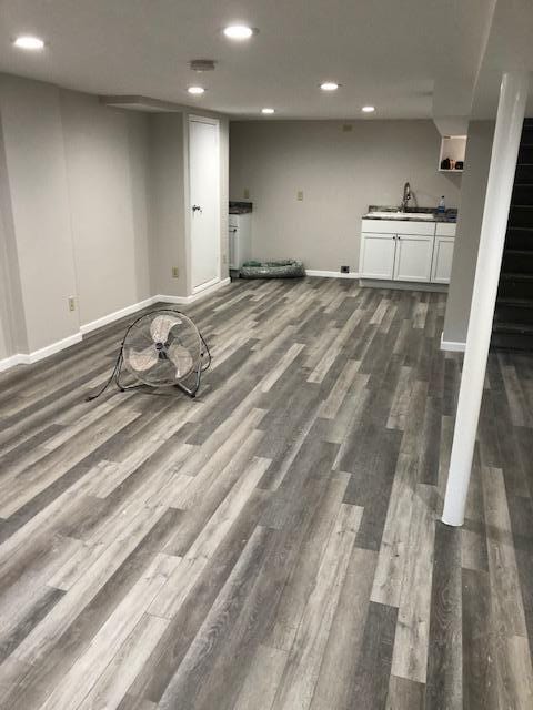 basement featuring sink and dark hardwood / wood-style floors