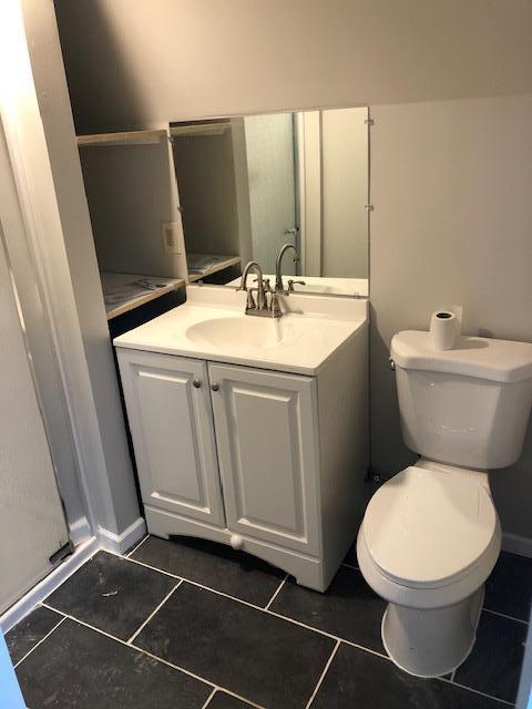 bathroom featuring tile patterned flooring, vanity, and toilet