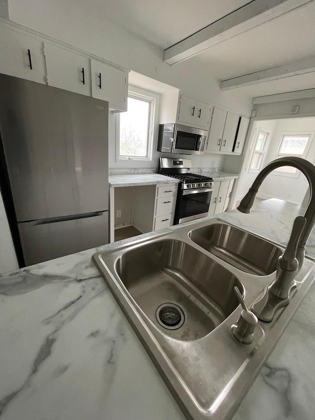 kitchen with white cabinetry, stainless steel appliances, and sink