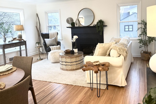 living area with hardwood / wood-style floors and a healthy amount of sunlight