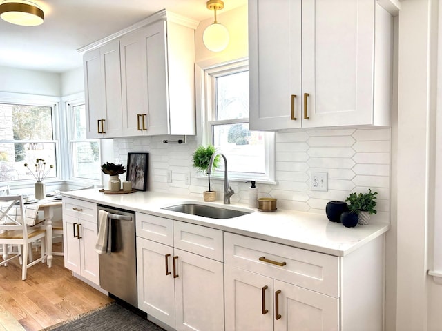 kitchen with dark hardwood / wood-style floors, pendant lighting, dishwasher, sink, and white cabinets