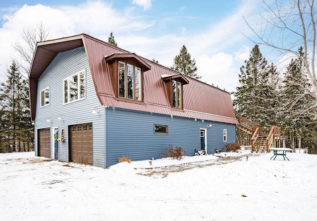 view of snow covered exterior with a garage