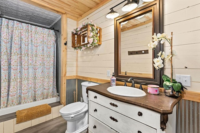 bathroom with wood ceiling, hardwood / wood-style flooring, wooden walls, vanity, and toilet