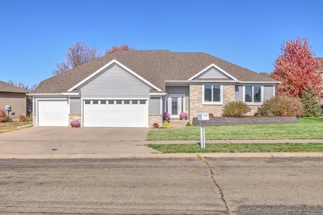 ranch-style house featuring driveway, a front lawn, an attached garage, and stone siding