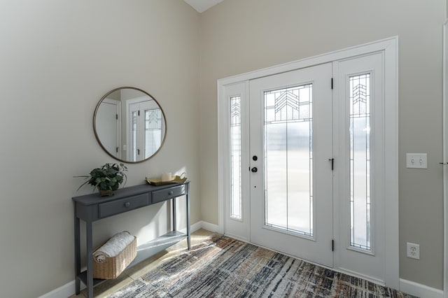 foyer with baseboards and a healthy amount of sunlight