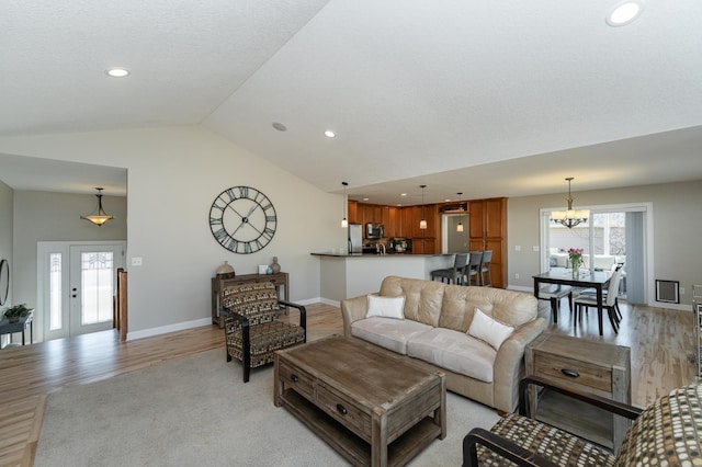 living area with vaulted ceiling, light wood finished floors, a chandelier, and recessed lighting