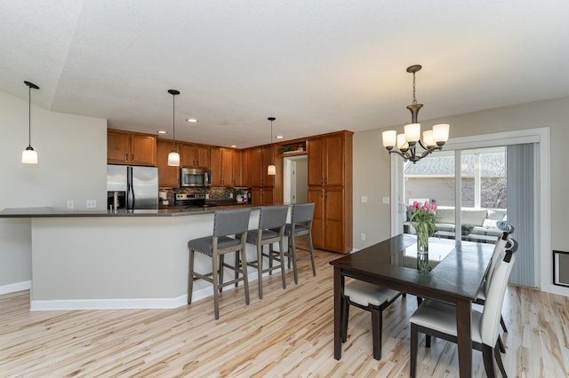 dining room with a chandelier, recessed lighting, baseboards, and light wood-style floors