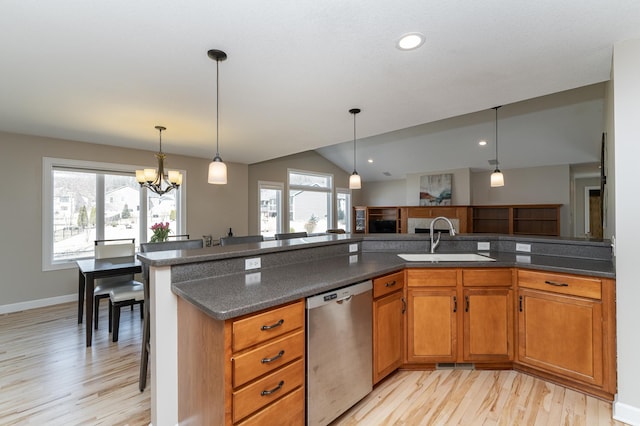 kitchen with a sink, a wealth of natural light, brown cabinetry, and dishwasher