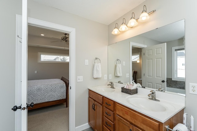 ensuite bathroom featuring ceiling fan, a sink, ensuite bath, and double vanity