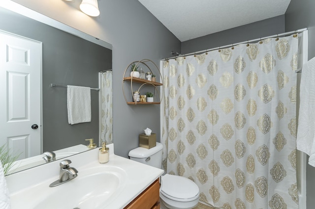 bathroom with a textured ceiling, a shower with shower curtain, vanity, and toilet