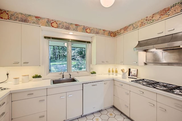 kitchen with light countertops, stainless steel gas stovetop, a sink, dishwasher, and under cabinet range hood