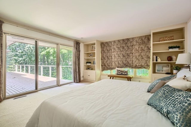 carpeted bedroom featuring access to outside, multiple windows, and visible vents