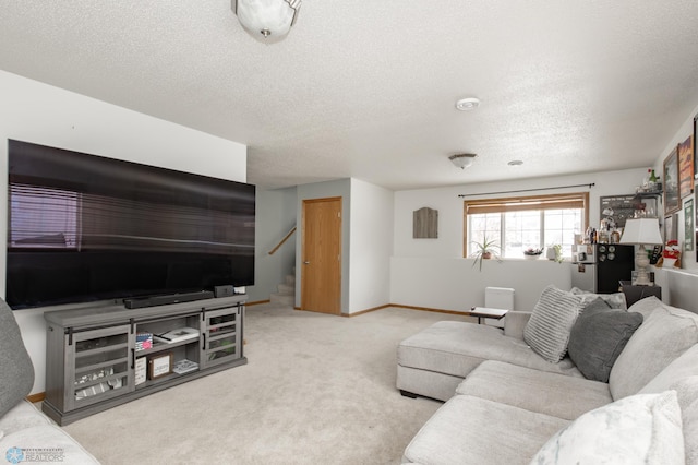 living area with carpet flooring, a textured ceiling, baseboards, and stairs