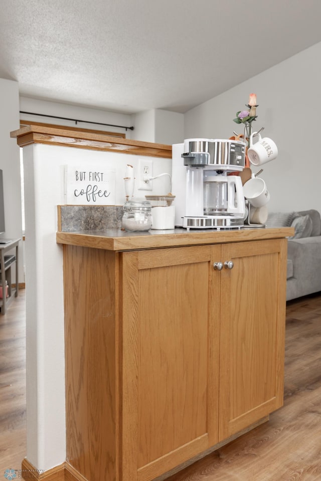 kitchen featuring light wood-style floors, light brown cabinets, and a textured ceiling