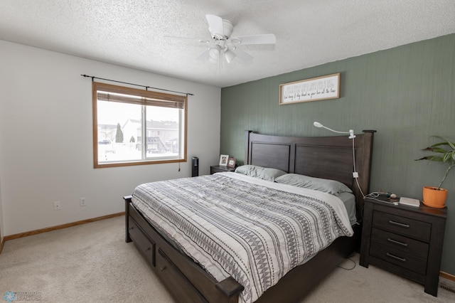 bedroom featuring ceiling fan, baseboards, a textured ceiling, and light colored carpet