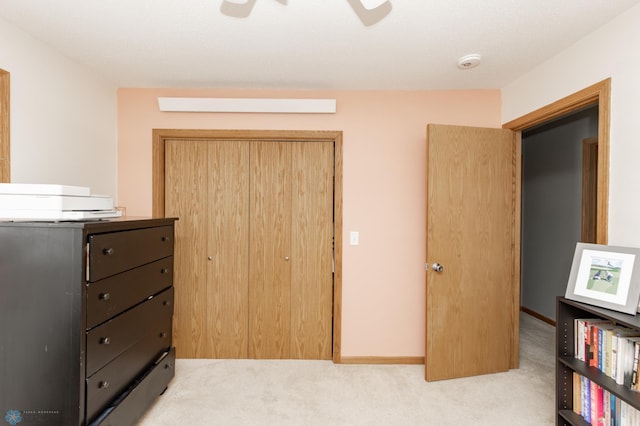 carpeted bedroom with a ceiling fan, a closet, and baseboards