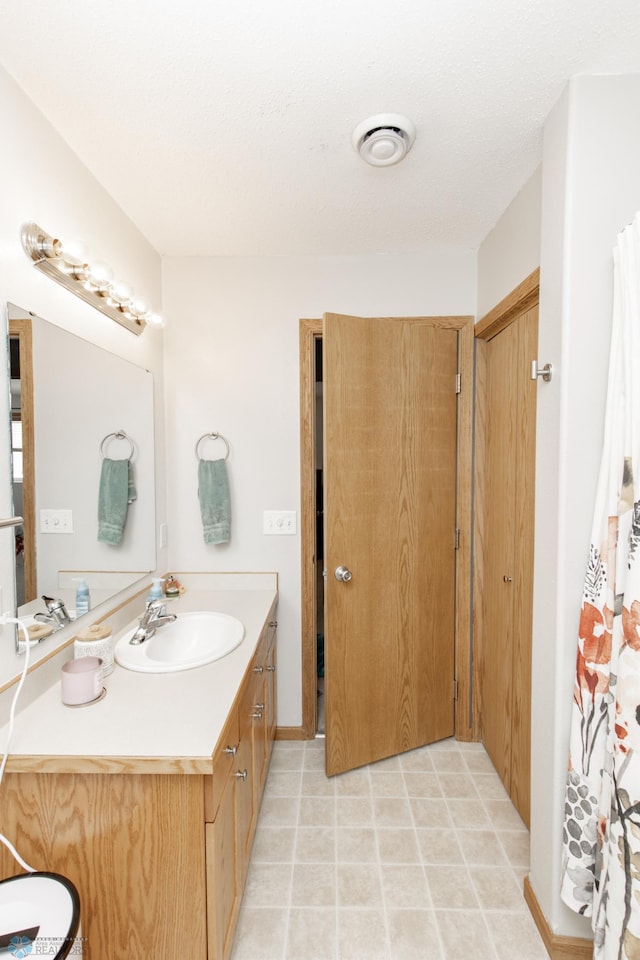 full bathroom with visible vents, vanity, and tile patterned floors