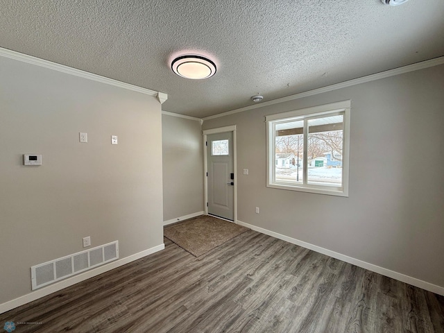 foyer featuring hardwood / wood-style floors, crown molding, and a textured ceiling