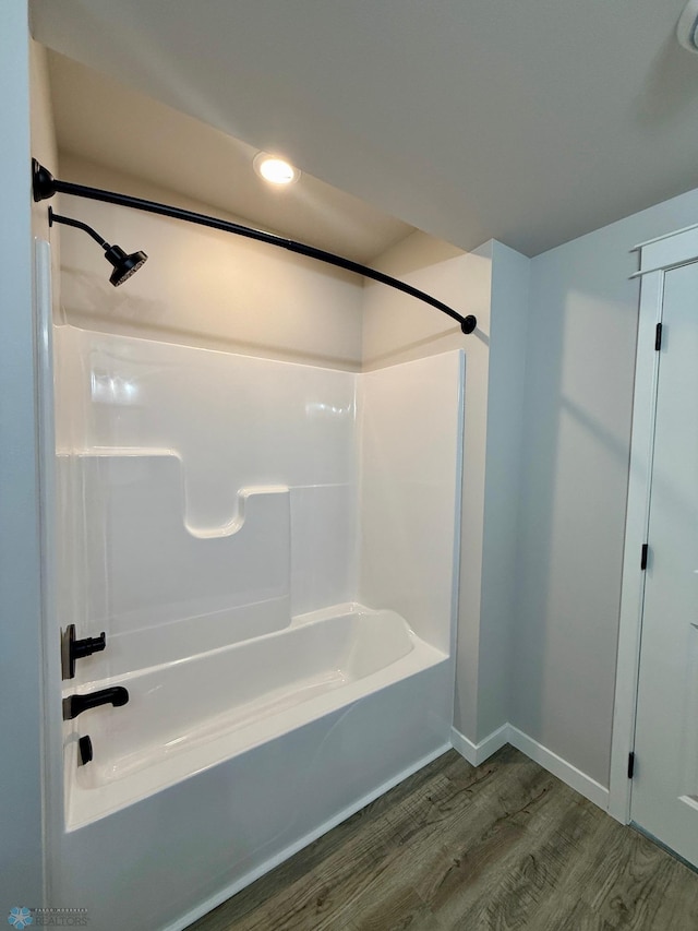 bathroom with hardwood / wood-style flooring and shower / bath combination