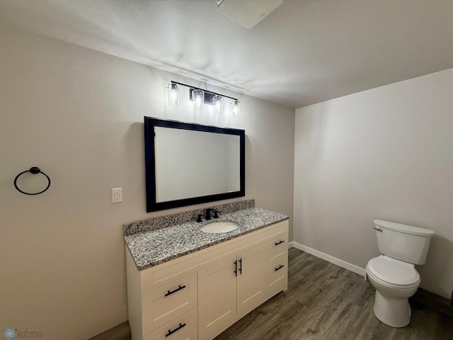 bathroom featuring vanity, hardwood / wood-style floors, and toilet