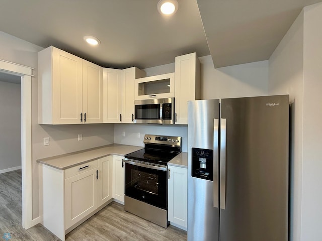 kitchen featuring white cabinetry, appliances with stainless steel finishes, and light hardwood / wood-style flooring