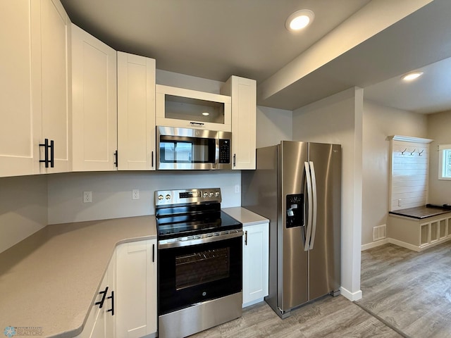 kitchen featuring white cabinetry, appliances with stainless steel finishes, and light hardwood / wood-style flooring