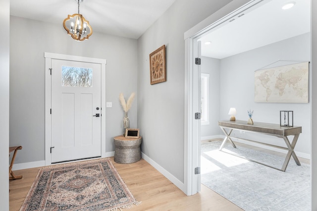 foyer entrance with a notable chandelier and light hardwood / wood-style floors