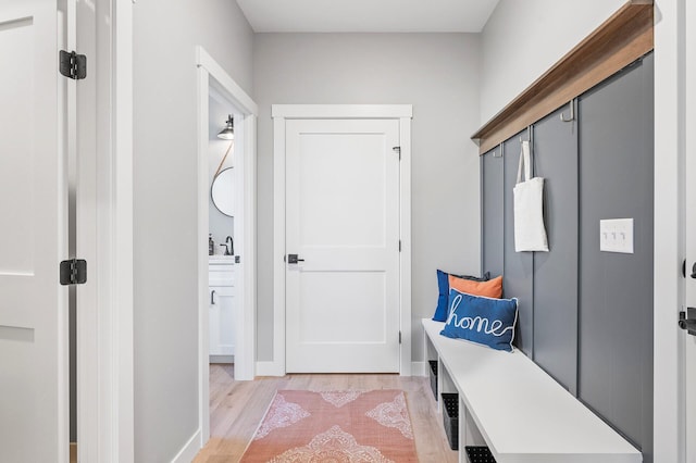 mudroom with sink and light hardwood / wood-style floors