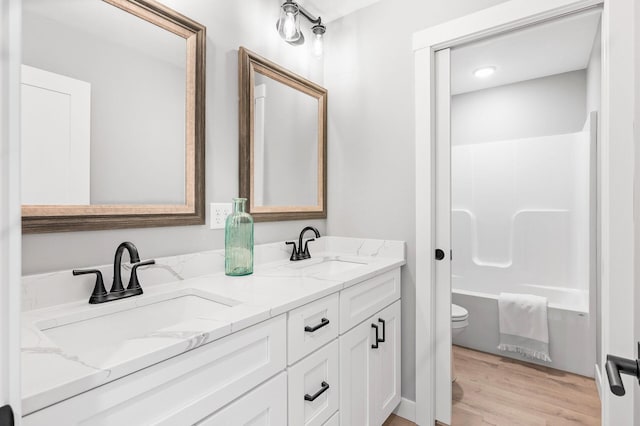 full bathroom with vanity, hardwood / wood-style floors, shower / washtub combination, and toilet