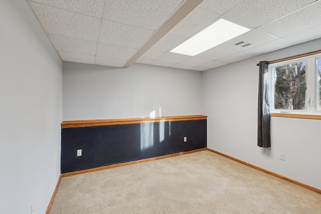 carpeted spare room featuring a paneled ceiling