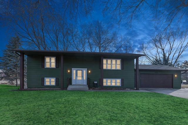 split foyer home featuring a garage and a lawn