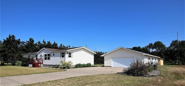 view of front of home featuring a garage, an outbuilding, and a front yard