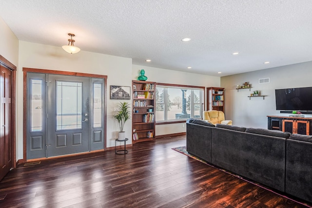 living area featuring recessed lighting, wood finished floors, visible vents, and a textured ceiling