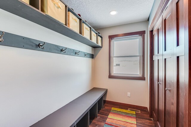 mudroom with dark wood-style floors, baseboards, and a textured ceiling