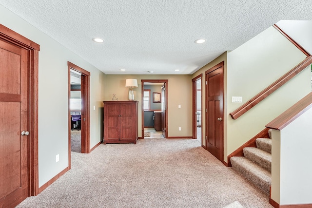 interior space featuring stairs, recessed lighting, light colored carpet, and baseboards