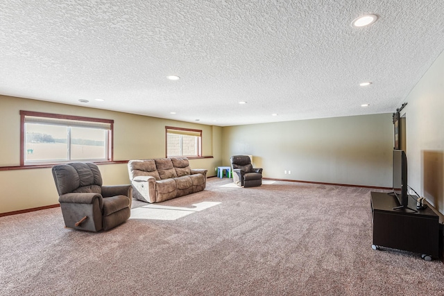 carpeted living area with a barn door, recessed lighting, and baseboards