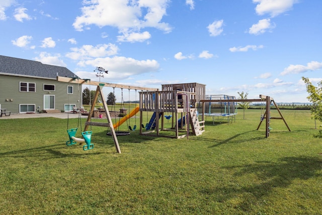 view of playground featuring a lawn, a trampoline, and a patio area