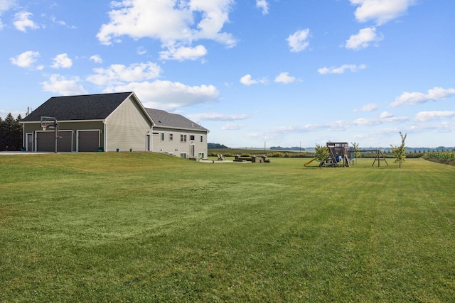 view of yard with a playground and a garage