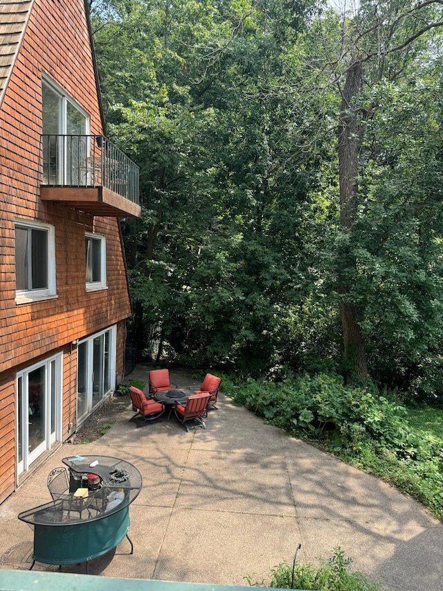 view of patio with a balcony and an outdoor fire pit