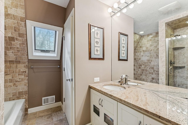 bathroom with vanity, shower with separate bathtub, tile patterned floors, and a textured ceiling