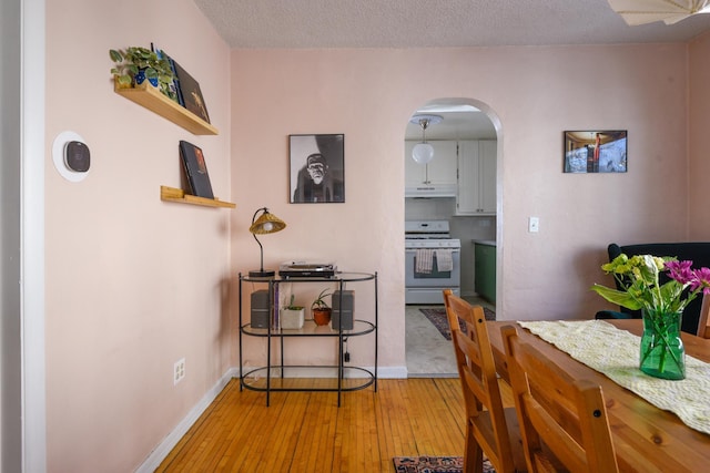 dining room with a textured ceiling and light wood-type flooring