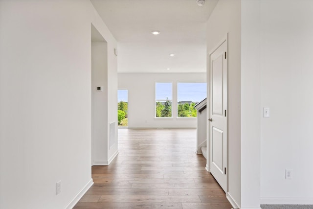 corridor with hardwood / wood-style flooring