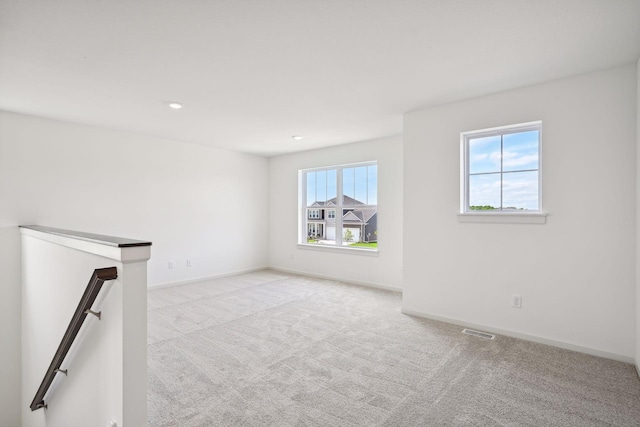 unfurnished room with a healthy amount of sunlight and light carpet