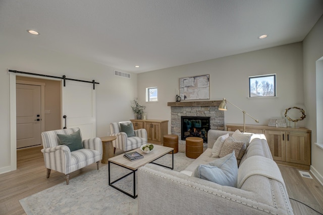 1205 Riverside Dr N, North Hudson, WI 54016 - living area with a barn door, light wood-style flooring, recessed lighting, a fireplace, and baseboards