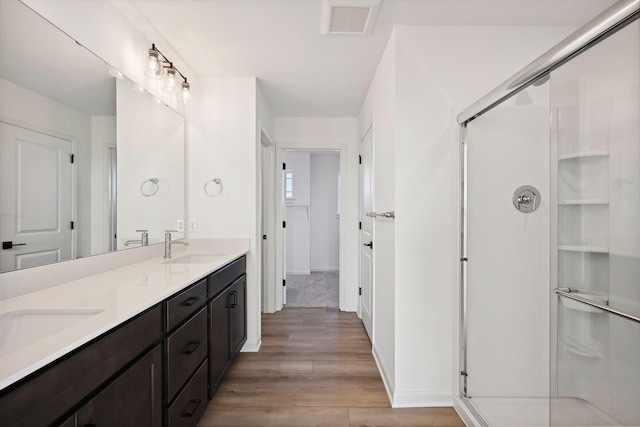 bathroom featuring vanity, hardwood / wood-style floors, and a shower with door