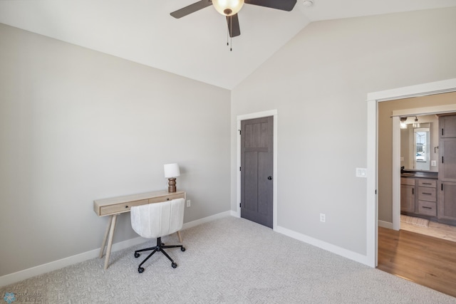 carpeted home office featuring vaulted ceiling