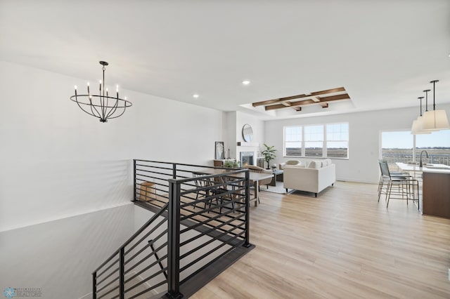 dining space featuring baseboards, an inviting chandelier, light wood-type flooring, recessed lighting, and a lit fireplace