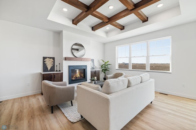 living room with light wood-style floors, visible vents, baseboards, and coffered ceiling